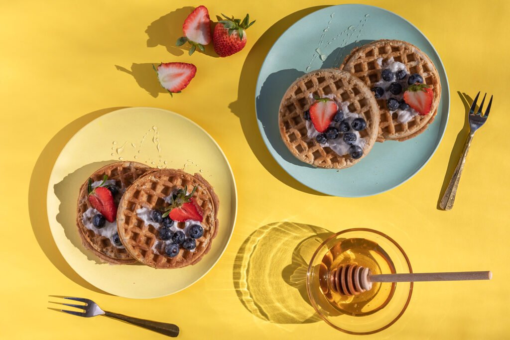 Blueberry and strawberry waffles on teal and yellow plates, moody food photography by Pine Tree Ca